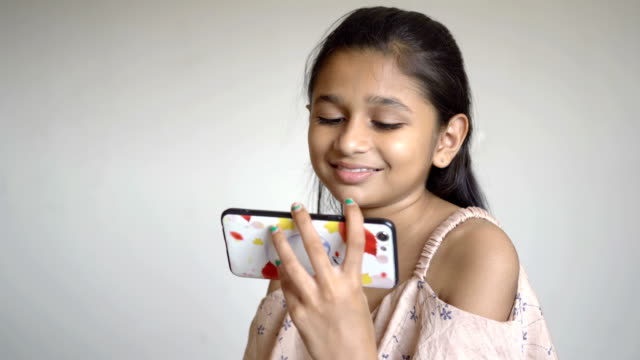 Niña-india-está-viendo-dibujos-animados-en-el-teléfono-inteligente
