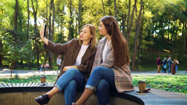 Glückliche-Blogger-kommunizieren-mit-ihren-Anhängern-mit-Smartphone-im-Park
