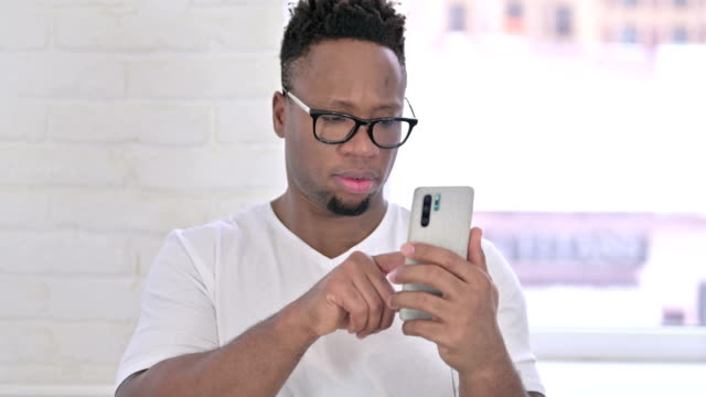 The-Portrait-of-Relaxed-Casual-African-Man-using-Smartphone