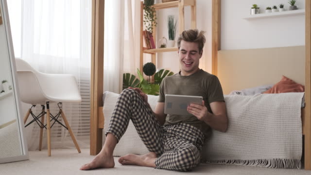 Mann-mit-digitalem-Tablet-im-Schlafzimmer