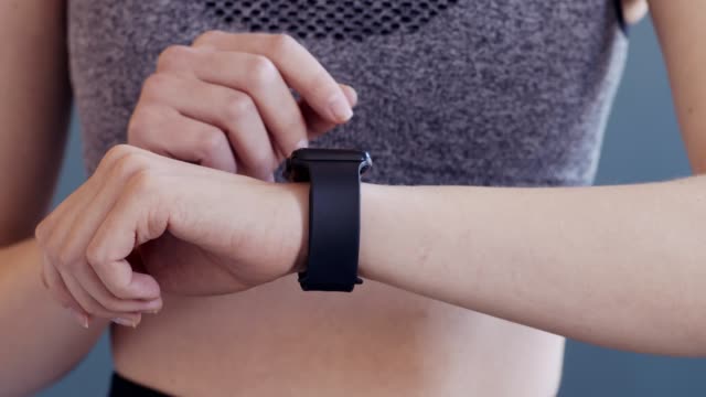 Fit-girl-using-fitness-bracelet-before-active-workout,-close-up
