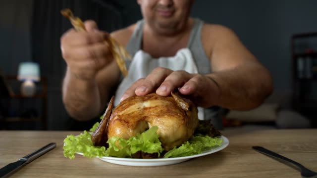 Hombre-regordete-comiendo-pollo-frito-grasa-con-avidez,-alimentos-altos-en-calorías-y-adicción