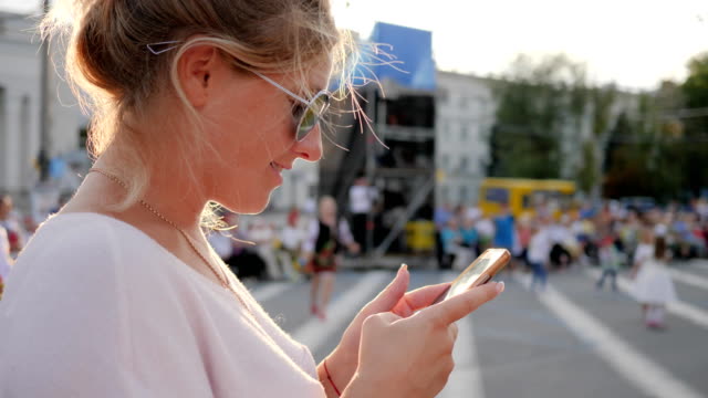 junge-Frau-in-Gläser-mit-Smartphone-in-Händen-bei-Street-in-der-Innenstadt-von