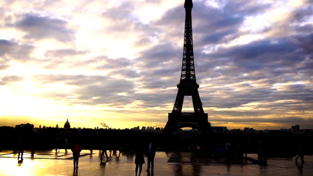 Passengers-walking-near-Eiffel-Tower-with-sunset-background