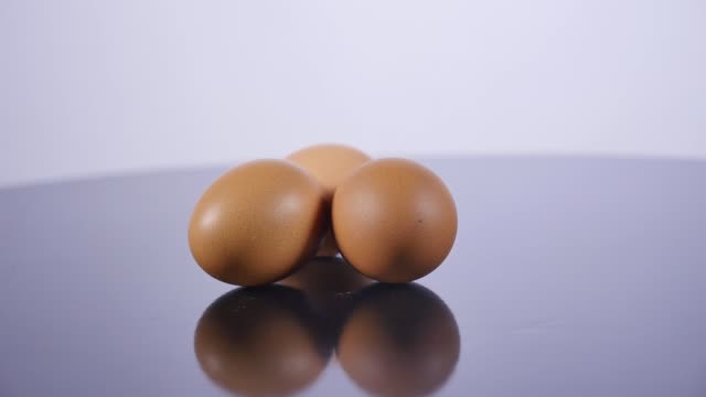 Three-raw-eggs-lie-on-a-white-table