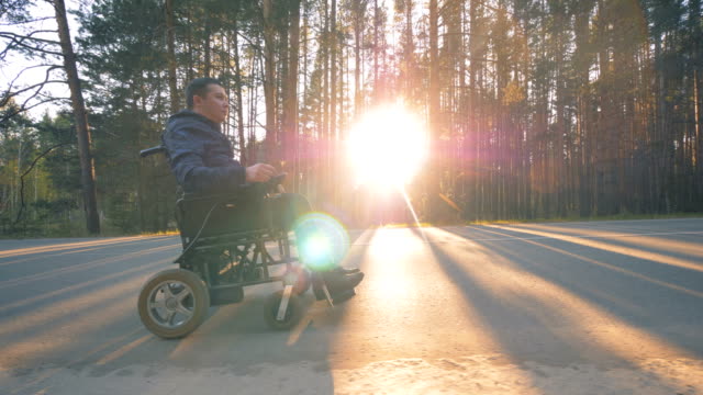 Persona-con-discapacidad-paseos-en-silla-de-ruedas-en-el-camino.