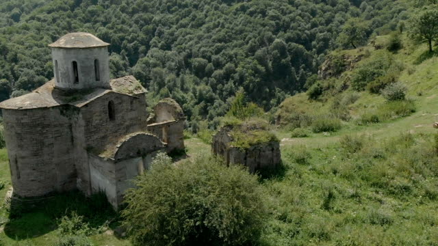 Departure-on-a-drone-over-the-ancient-dilapidated-Christian-church-standing-high-on-the-mountain.-Aerial-View.-North-Caucasus.-Russia