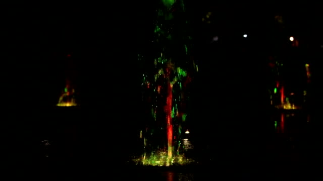 Fuente-de-agua-de-la-noche-bailando-con-fondo-de-imágenes-de-blur-multicolores-luces-de-color,-planos,-profundidad-de-campo,-59,94-fps