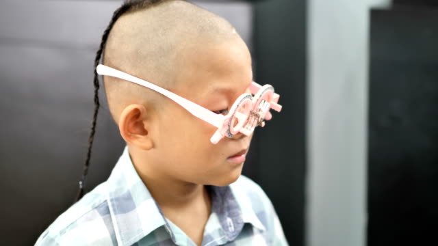 eyesight-check.-Asian-boys-who-have-vision-disabilities.-Left-eye-is-not-visible-from-brain-surgery.-Medical-treatment-and-Rehabilitation.-video-4k