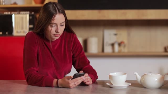 Junge-Frau-im-Internet-surfen,-Überprüfung-von-Neuigkeiten-in-sozialen-Netzwerken-mit-Smartphone-in-der-Küche.