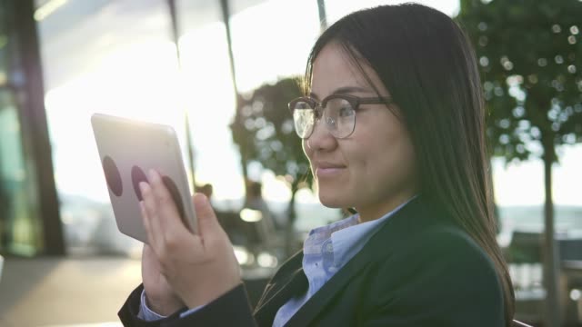 Asiatische-Geschäftsfrau-arbeiten-an-digital-Tablette-am-Flughafen