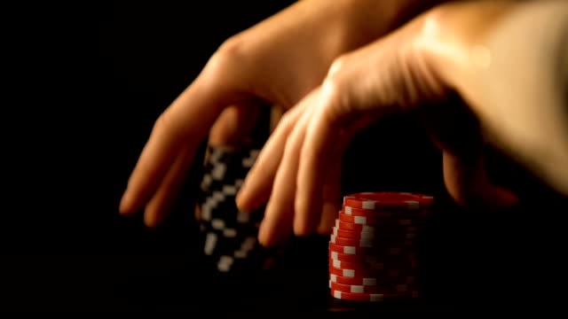 Hand-putting-red-and-black-poker-chips,-illegal-gambling,-casino-business