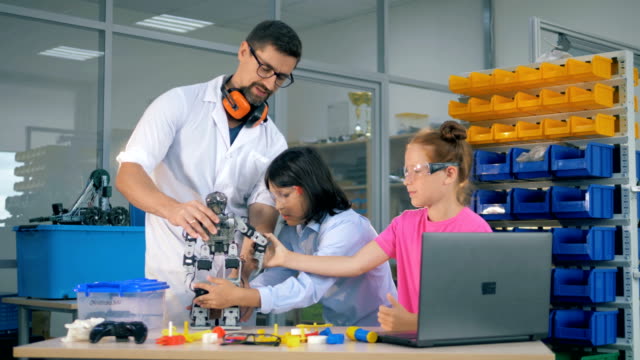 Schulwissender-Lehrer-studieren-Robotik-Technik-mit-intelligenten-Schülern