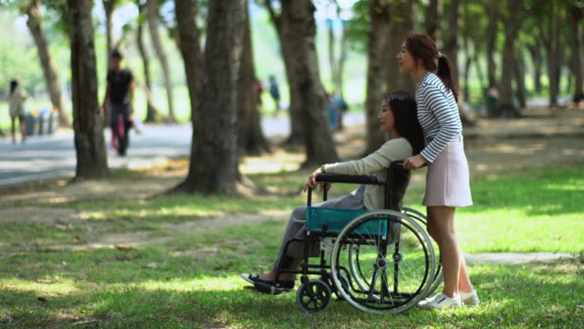Bonita-hija-adolescente-y-madre-en-silla-de-ruedas-en-el-Parque