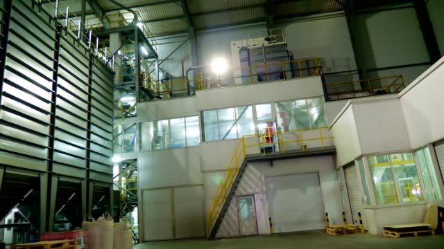 Interior-de-una-fábrica-moderna,-local-de-hangar-grande-industrial,-almacén.-Grandes-estructuras-de-acero-para-plantas,-tuberías,-escaleras,-paneles,-paneles-de-control-de-diversos-procesos-técnicos-automatizados