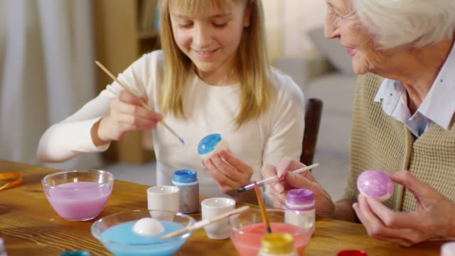 Grandmother-and-Granddaughter-Painting-Eggs-with-Gouache