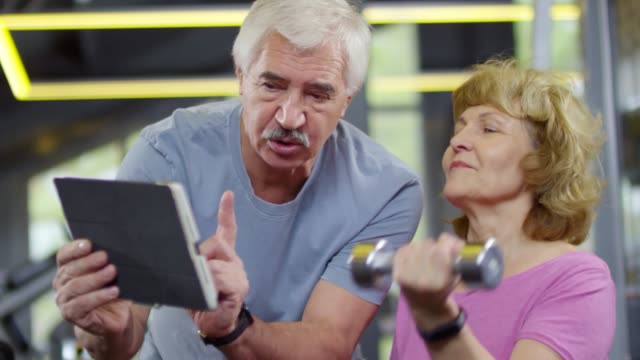 Zwei-Rentner-mit-Tablet-in-Gym