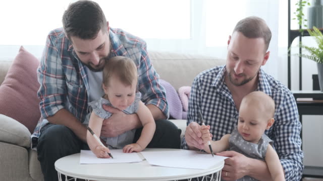 Zwei-Männer-mit-Baby-Mädchen-zeichnen-auf-Papier