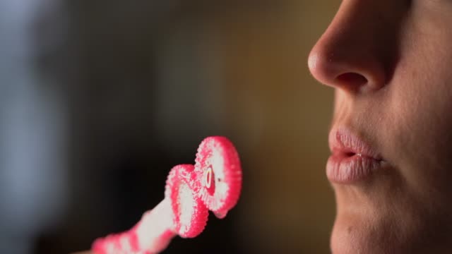 Nahaufnahme-Makro-Zeitlupe-Lippen-blasen-Blasen-aus-rosa-Blase-Zauberstab