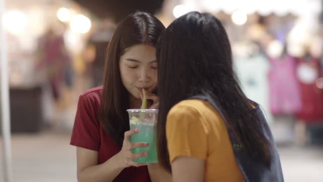Asiatische-junge-Frau-Freunde-reisen-in-Bangkok,-Thailand,-schöne-weibliche-Gefühl-glücklich-trinken-Cocktail-in-der-Khao-San-Road.-Frauen-reisen-essen-Street-Food-in-Thailand-Konzept.-Zeitlupenaufnahme.