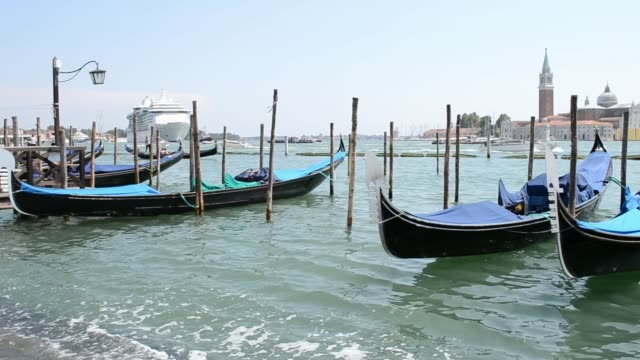 Lagunenpier-von-Venedig-mit-vielen-Gondeln-und-Ozean-Kreuzfahrtschiffen.