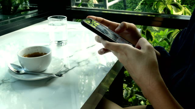 Una-joven-está-chateando-y-enviando-mensajes-de-texto-en-el-café-de-los-teléfonos-inteligentes.