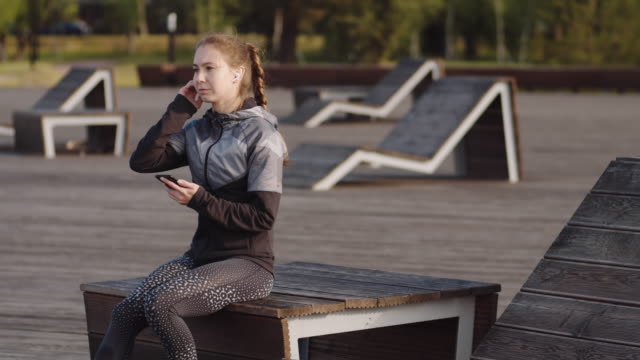 Sportswoman-Using-Phone-in-Park