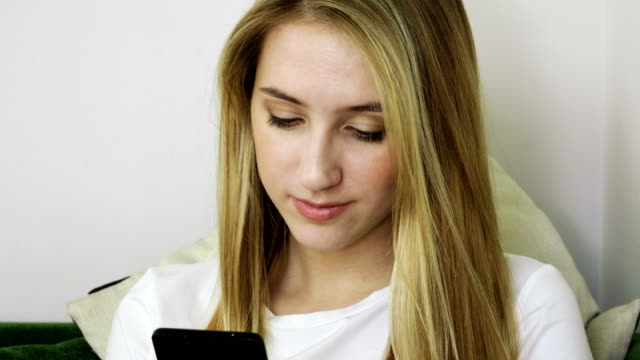 Junge-lächelnde-Frau-mit-Dem-Smartphone,-SMS-auf-dem-Handy-in-modernen-Café.-4K