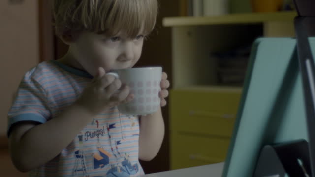 kleiner-Junge-essen-beim-Anschauen-digitaler-Tablet