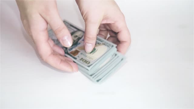 Weibliche-Hand-auf-weißem-Hintergrund-wirft-Geld-auf-den-Tisch