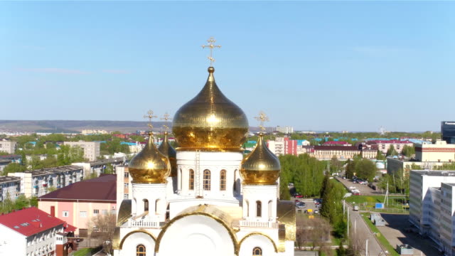Shining-Gold-Domes-on-Church-among-Modern-City-Aerial-View