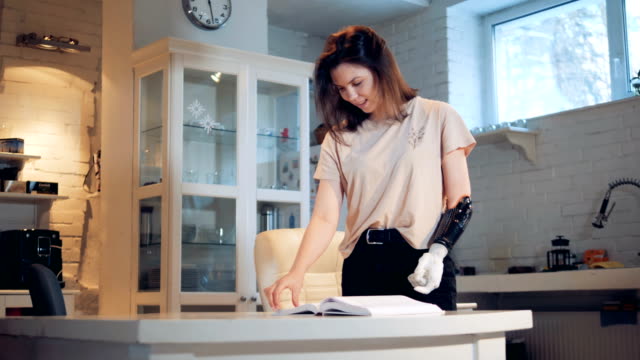 Behinderte-Frau-dreht-Seiten-mit-einer-Roboterprothese,-aus-nächster-Nähe.