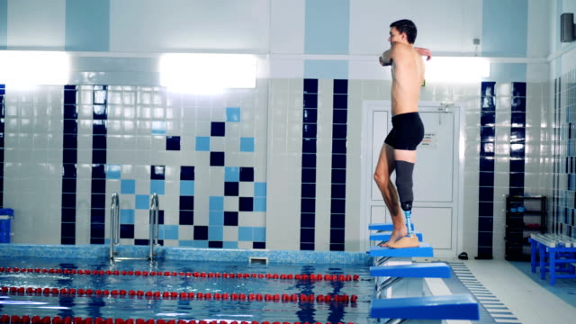 Ein-Mann-mit-einem-bionischen-Bein-dehnt-Muskeln,-um-in-den-Pool-zu-springen