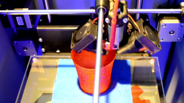 La-impresora-3D-crea-un-jarrón-rojo-redondo,-vista-desde-arriba