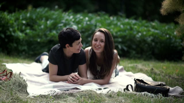 Lesbians-relaxing-and-flirting-on-grass-in-park