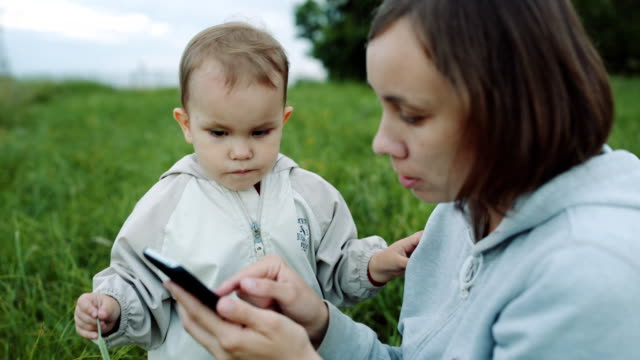 Woman-showing-something-to-her-child-on-the-smartphone.