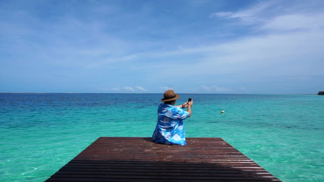 turística-mediante-teléfono-inteligente-panorama-vista-paraíso-hermoso-océano