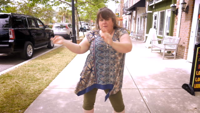 An-obese-woman-pointing-and-dancing-around-celebrating-success