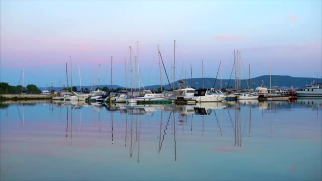 Eine-ruhige-Seenlandschaft,-eine-kleine-Yacht-mit-einem-abgesenkten-Stand-im-Hafen-am-Abend