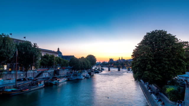 Mira-en-el-Pont-des-Arts-en-París-después-de-puesta-del-sol-día-noche-timelapse,-Francia
