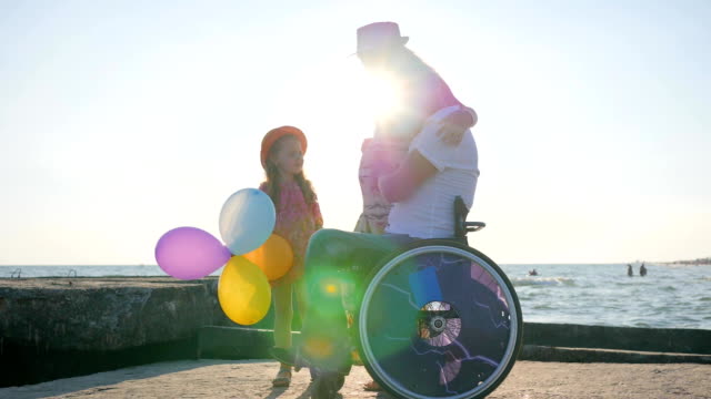 Liebhaber-von-Behinderten-im-Rollstuhl-mit-glücklichen-Familie-Kind-betrachten-Bauch-der-schwangeren-Mutter-Urlaub