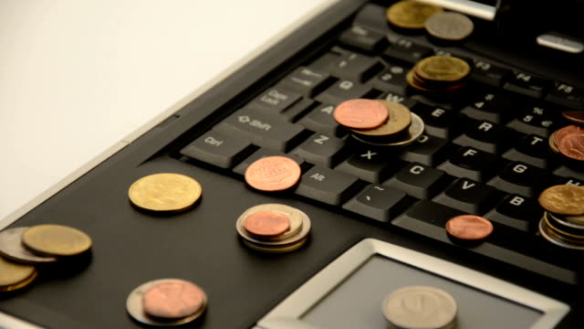 Münzen-auf-einem-Laptop-isoliert-auf-weißem-Hintergrund
