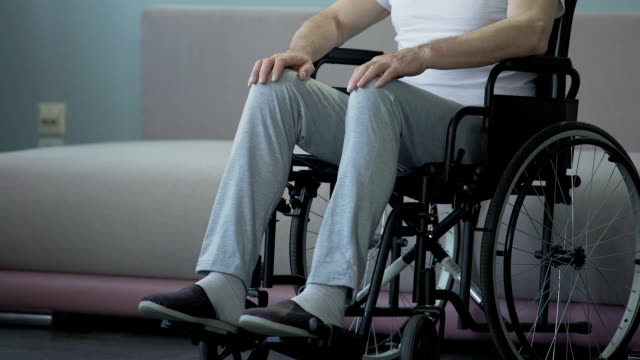 Einsamer-alter-Mann-mit-Behinderungen-leider-Blick-aus-Fenster,-sitzen-im-Rollstuhl