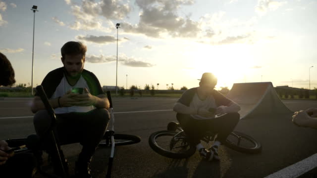 Biker-Boys-ruhen-nach-dem-Radfahren-Rennen-Überprüfung-Smartphones-gerade-social-Media-Netzwerk-Nachrichten