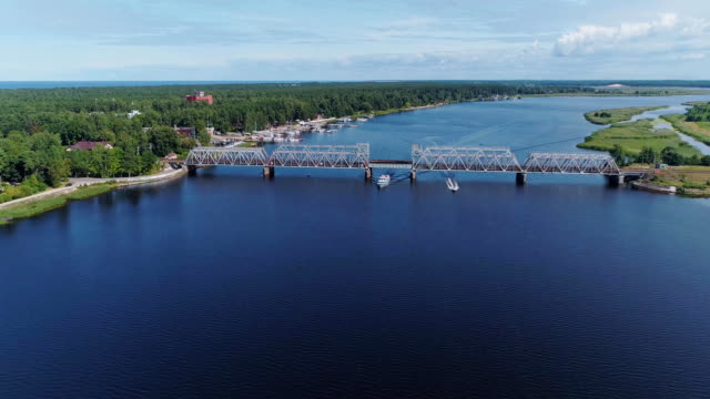 Bahnbrücke-Drohne-Flightabove-Lielupe-Flusses-Jurmala-Stadt,-grüne-Natur,-Schiff-Boot