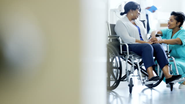 Afrikanische-amerikanische-Krankenschwester-und-Patient-im-Rollstuhl