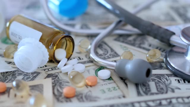 medical,-treatment-expenses,-concept,-pills-on-money,-dollars,-dolly-shot