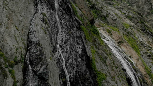 Tracking-und-oben-geschossen-Luft-aus-einem-Strom-von-Spritzwasser-Wasserfall-auf-einer-Felswand-in-den-Bergen-des-Kaukasus-gedreht.-Nahe-der-Jet-des-Wasserfalls