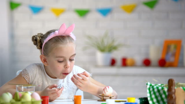 Small-girl-secretly-eating-chocolate-egg,-childhood,-preparation-for-Easter