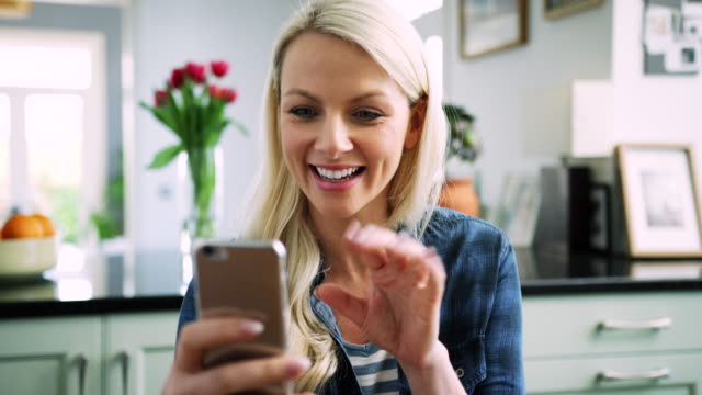 Mujer-rubia-feliz-con-Chat-de-Video-en-teléfonos-inteligentes